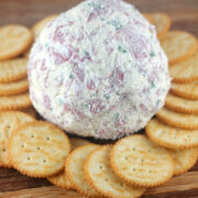 Cheese ball with crackers on wooden board