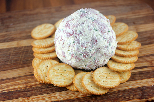 Cheese ball with crackers on wooden board