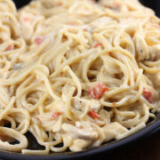 Plate of creamy cheesy chicken spaghetti with diced tomatoes