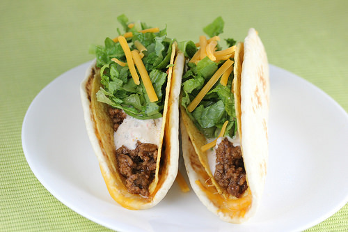 Cheesy gordita crunch tacos stuffed with ground beef, lettuce, shredded cheese, and creamy sauce