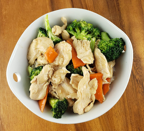 White bowl filled with chicken broccoli stir fry