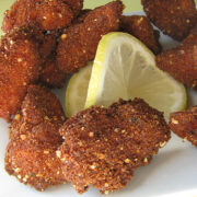 Plate of crispy fried chicken nuggets with lemon wedge