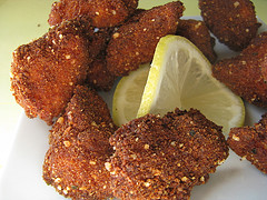 Plate of crispy fried chicken nuggets with lemon wedge
