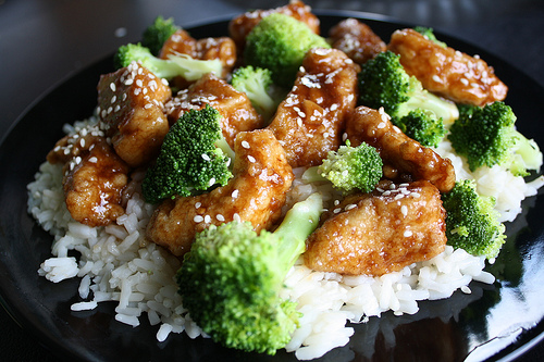Chicken and broccoli stir fry served over white rice with sesame seeds