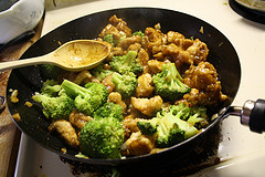 Chicken and broccoli cooking in a wok with sauce