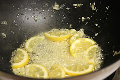 Pan with lemon slices and garlic cooking