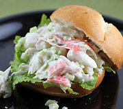 Crab salad sandwich on lettuce and a sandwich roll