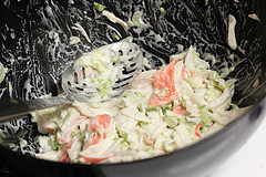 Mixing crab salad with celery and mayonnaise in a bowl