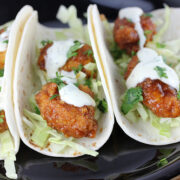 Soft tortillas filled with crispy chicken, cabbage, and sauce