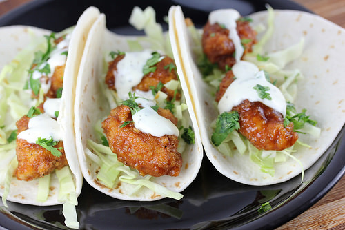 Soft tortillas filled with crispy chicken, cabbage, and sauce