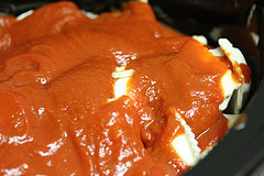Ravioli simmering in rich tomato sauce in slow cooker