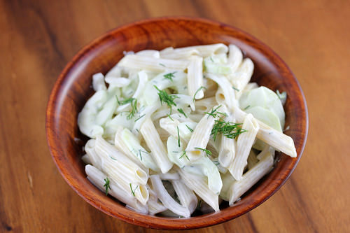 Bowl of cucumber pasta salad with penne, cucumber slices, and dill