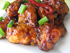 Glazed General Tso’s chicken topped with chopped green onions and red chili pepper