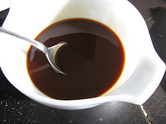 Bowl of dark soy-based sauce with a spoon for General Tso’s chicken