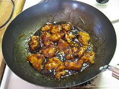 General Tso’s chicken cooking in sauce inside a wok