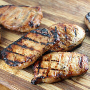 Grilled honey soy pork chops on a wooden board