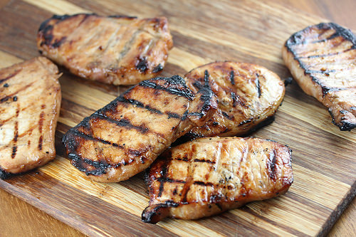Grilled honey soy pork chops on a wooden board