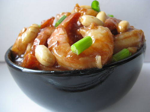 Bowl of Kung Pao shrimp with peanuts and green onions
