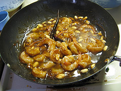 Shrimp cooking with peanuts and sauce in wok