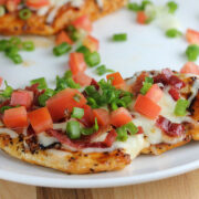 Grilled chicken breast topped with melted cheese, bacon, tomatoes, and green onions