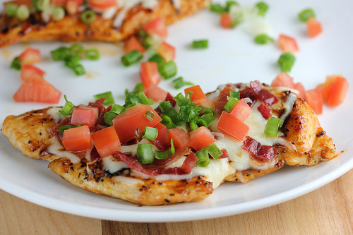 Grilled chicken breast topped with melted cheese, bacon, tomatoes, and green onions