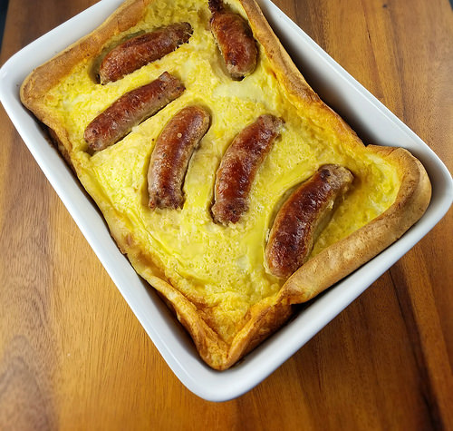 Baked toad in the hole with sausages in golden Yorkshire pudding