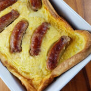 Close-up of toad in the hole showing browned sausages in baked batter