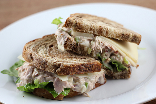 Close-up of tuna salad sandwich halves on rye bread with lettuce and cheese