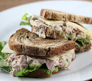 Cut tuna salad sandwich with lettuce and cheese on rye bread
