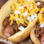 Cincinnati cheese coney topped with chili, shredded cheddar, and diced onions