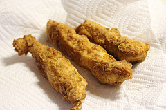 Fried chicken strips resting on paper towels after cooking