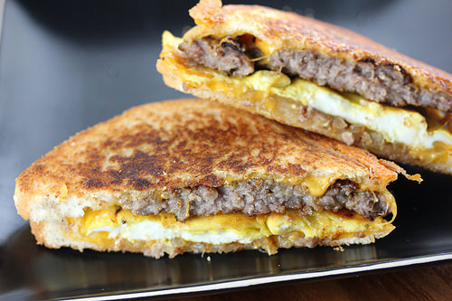 Breakfast patty melt sandwich with sausage, egg, and cheese on toasted bread