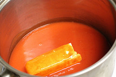 Butter melting into buffalo sauce in a saucepan