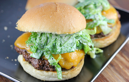 Cheddar cheeseburger topped with romaine slaw on a toasted bun