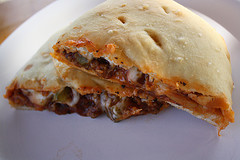 Sliced calzone filled with meat, cheese, and vegetables