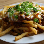 Close-up of chili cheese fries garnished with chopped green onions