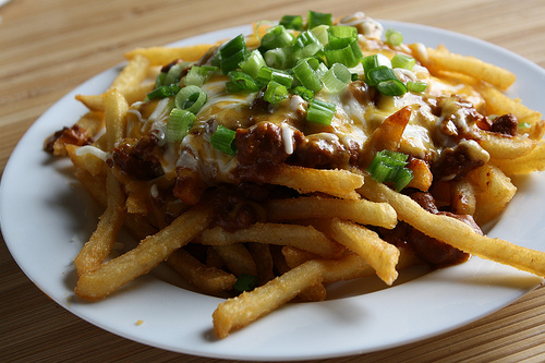 Close-up of chili cheese fries garnished with chopped green onions