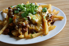 Plate of loaded chili cheese fries with melted cheese
