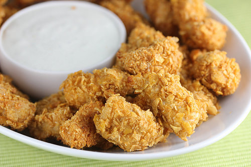 Close-up of golden chicken poppers with dipping sauce