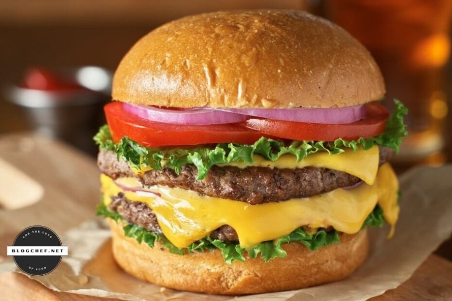 close up of prepared hamburger with cheese and toppings