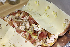 Chicken sub topped with bacon and Swiss cheese before baking