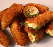Fried jalapeño poppers with cheesy filling on a plate