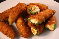 Fried jalapeño poppers with cheesy filling on a plate