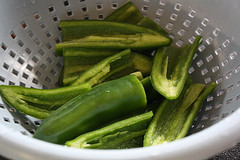 Sliced raw jalapeños in a strainer