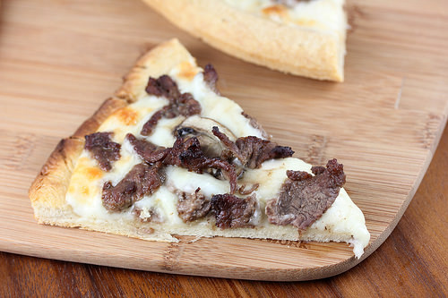Philly cheesesteak pizza topped with mushrooms and green peppers