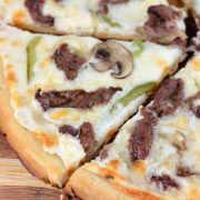 Philly cheesesteak pizza topped with mushrooms and green peppers