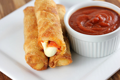 Close-up of crispy pizza sticks served with marinara dip