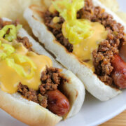 Sloppy joe hot dogs topped with cheese sauce and pepper rings