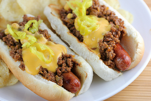 Sloppy joe hot dogs topped with cheese sauce and pepper rings