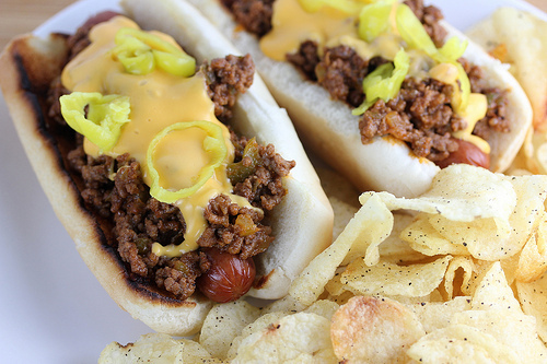 Sloppy joe hot dogs topped with cheese sauce and pepper rings